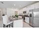 Bright kitchen featuring an island with seating, granite counters, and stainless appliances at 6347 Ten Acre Ct, Zephyrhills, FL 33541