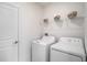 Clean laundry room featuring a modern washer and dryer set with shelves for storage and white door at 6347 Ten Acre Ct, Zephyrhills, FL 33541