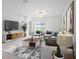 Bright and airy living room featuring stylish furniture, a modern rug, and neutral decor at 6347 Ten Acre Ct, Zephyrhills, FL 33541