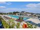 Community pool with lounge chairs and lush landscaping at 6347 Ten Acre Ct, Zephyrhills, FL 33541