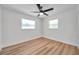 Light-filled bedroom with two windows, wood-look flooring, and a ceiling fan for comfort at 6352 Canton S St, St Petersburg, FL 33712