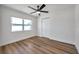 Cozy bedroom with wood-look floors, a ceiling fan, and a large window, creating a serene atmosphere at 6352 Canton S St, St Petersburg, FL 33712