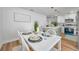 Bright dining area featuring a white table set for four, complemented by an open kitchen with modern finishes at 6352 Canton S St, St Petersburg, FL 33712