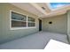 Spacious covered front porch with painted brick walls, black door, and a large window at 6352 Canton S St, St Petersburg, FL 33712