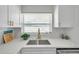 Bright kitchen area with updated white countertops, mosaic tile backsplash, and stainless steel sink at 6352 Canton S St, St Petersburg, FL 33712