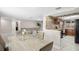 View of living room, dining area, and kitchen, showcasing the home's layout and neutral color palette at 6715 Ranchwood Loop, New Port Richey, FL 34653