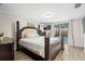 Bedroom with a wooden floor, a full-size bed, and sliding doors to the backyard pool at 6715 Ranchwood Loop, New Port Richey, FL 34653