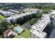 Aerial view showcasing complex, pond, pool, tennis, and shuffleboard at 7941 58Th N Ave # 301, St Petersburg, FL 33709