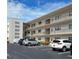Condo building with a well-maintained exterior, balconies, and assigned parking spaces for residents and visitors at 7941 58Th N Ave # 301, St Petersburg, FL 33709