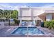 Community hot tub with nearby chairs, landscaping, and spa rules signage at 7941 58Th N Ave # 301, St Petersburg, FL 33709