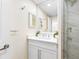 Bright bathroom features a modern white vanity, large mirror, and walk-in shower with marble tile at 7979 Sailboat Key S Blvd # 505, South Pasadena, FL 33707