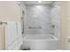 Modern bathroom with white tiled shower and tub, featuring sleek fixtures and grab bars for accessibility at 7979 Sailboat Key S Blvd # 505, South Pasadena, FL 33707