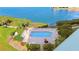 Aerial view of the community pool featuring lounge chairs and landscaping with water view beyond at 7979 Sailboat Key S Blvd # 505, South Pasadena, FL 33707