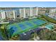 Aerial view of well-maintained tennis courts surrounded by lush landscaping and condos at 7979 Sailboat Key S Blvd # 505, South Pasadena, FL 33707