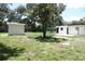 Wide backyard featuring shed, partial fencing, patio, and mature landscaping at 814 W 131St Ave, Tampa, FL 33612