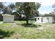 View of backyard with home, shed and mature landscaping at 814 W 131St Ave, Tampa, FL 33612