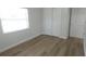 A simple, clean bedroom with hardwood flooring, a large closet, and natural light at 814 W 131St Ave, Tampa, FL 33612
