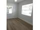 Sunlit bedroom with wood-look flooring and two large windows at 814 W 131St Ave, Tampa, FL 33612