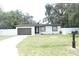 Charming home with a well-maintained lawn, updated garage door, and white picket fence at 814 W 131St Ave, Tampa, FL 33612