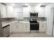 Modern kitchen featuring white cabinets, stainless steel appliances, and stylish backsplash at 814 W 131St Ave, Tampa, FL 33612