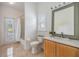 Well-lit bathroom with a wooden vanity and an open shower with access to the outside with a full-length glass door at 9126 Cypress Keep Ln, Odessa, FL 33556
