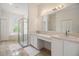 Bright bathroom with double vanity, glass shower, and separate tub underneath a large window with beautiful outside views at 9126 Cypress Keep Ln, Odessa, FL 33556