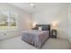 Comfortable bedroom with soft gray tones, plush bedding, and natural light streaming through the window with plantation shutters at 9126 Cypress Keep Ln, Odessa, FL 33556