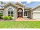 Charming single-story home with a well-manicured lawn, lush landscaping, and a two-car garage at 9126 Cypress Keep Ln, Odessa, FL 33556