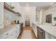 Modern, white kitchen featuring marble countertops, stainless steel appliances and ample counter space at 9126 Cypress Keep Ln, Odessa, FL 33556