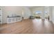 Inviting living room with bright wood flooring, a console, and views of the outdoors through large windows and sliding glass doors at 9126 Cypress Keep Ln, Odessa, FL 33556