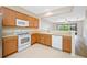 Bright kitchen with wood cabinets, white appliances, and tile floors at 10208 Westpark Preserve Blvd, Tampa, FL 33625