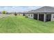 The backyard features a large expanse of green grass, perfect for outdoor activities and relaxation at 10278 Otter Sky Ct, San Antonio, FL 33576