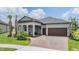 Charming single-story home featuring a brick-paved driveway and a welcoming covered porch with classic columns at 10278 Otter Sky Ct, San Antonio, FL 33576