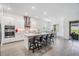 Modern kitchen with central island and barstools adjacent to a dining area and outdoor patio at 10278 Otter Sky Ct, San Antonio, FL 33576