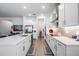 Modern kitchen featuring stainless steel appliances, white cabinets, and a spacious quartz countertop island at 10278 Otter Sky Ct, San Antonio, FL 33576