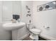 Stylish powder room with a pedestal sink, modern fixtures, and decorative wall art at 10278 Otter Sky Ct, San Antonio, FL 33576