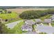 Aerial view of a solar-paneled home situated on a large lot near a tranquil pond at 10701 Morning Dew Way, Tampa, FL 33647