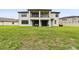 Spacious backyard featuring a covered patio and balcony in the rear of this home, with green grass at 10701 Morning Dew Way, Tampa, FL 33647