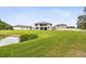 Overlooking a pond, the home has a spacious green backyard with a covered patio and balcony at 10701 Morning Dew Way, Tampa, FL 33647