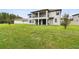 Large green backyard featuring a covered patio and balcony in the rear of this two-story home at 10701 Morning Dew Way, Tampa, FL 33647