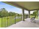 Covered balcony offers serene views of the surrounding nature and a tranquil pond at 10701 Morning Dew Way, Tampa, FL 33647