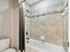 Bathroom shower and tub features neutral tile, modern shower head, and shower curtain at 10701 Morning Dew Way, Tampa, FL 33647