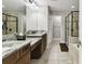 Bathroom features dual sinks with granite counters, glass shower, and a garden tub at 10701 Morning Dew Way, Tampa, FL 33647