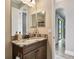 Bathroom featuring granite counters, dark cabinets, and framed vanity mirror at 10701 Morning Dew Way, Tampa, FL 33647