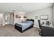 Bedroom with a queen bed, large windows, neutral carpeting, and a desk at 10701 Morning Dew Way, Tampa, FL 33647