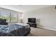 Bedroom with a queen bed, large windows, neutral carpeting, and a TV at 10701 Morning Dew Way, Tampa, FL 33647