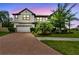 Beautiful two-story house with well-manicured lawn and garden at dusk at 10701 Morning Dew Way, Tampa, FL 33647