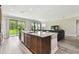 Open-concept kitchen and living area with granite island and hardwood flooring at 10701 Morning Dew Way, Tampa, FL 33647