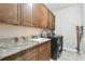 Functional laundry room featuring wood cabinets, countertop, and appliances at 10701 Morning Dew Way, Tampa, FL 33647