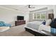 A well-lit main bedroom with a tray ceiling and large window at 10701 Morning Dew Way, Tampa, FL 33647